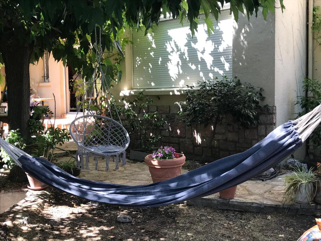 a blue hammock in a yard with a chair and a chair at Villa, avec piscine chauffée in Servian