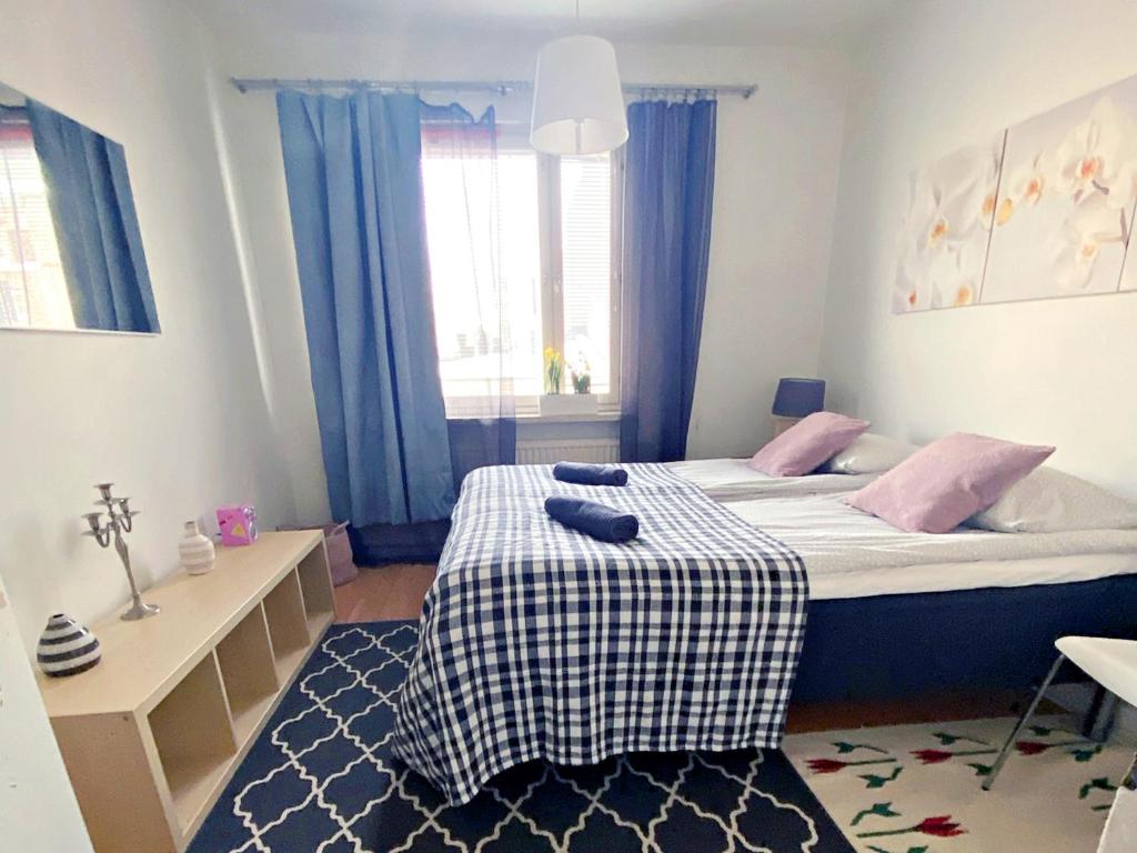 a small bedroom with a bed with a checkered blanket at Scandinavian Sweet home 30 Työmiehenkatu 2 in Helsinki