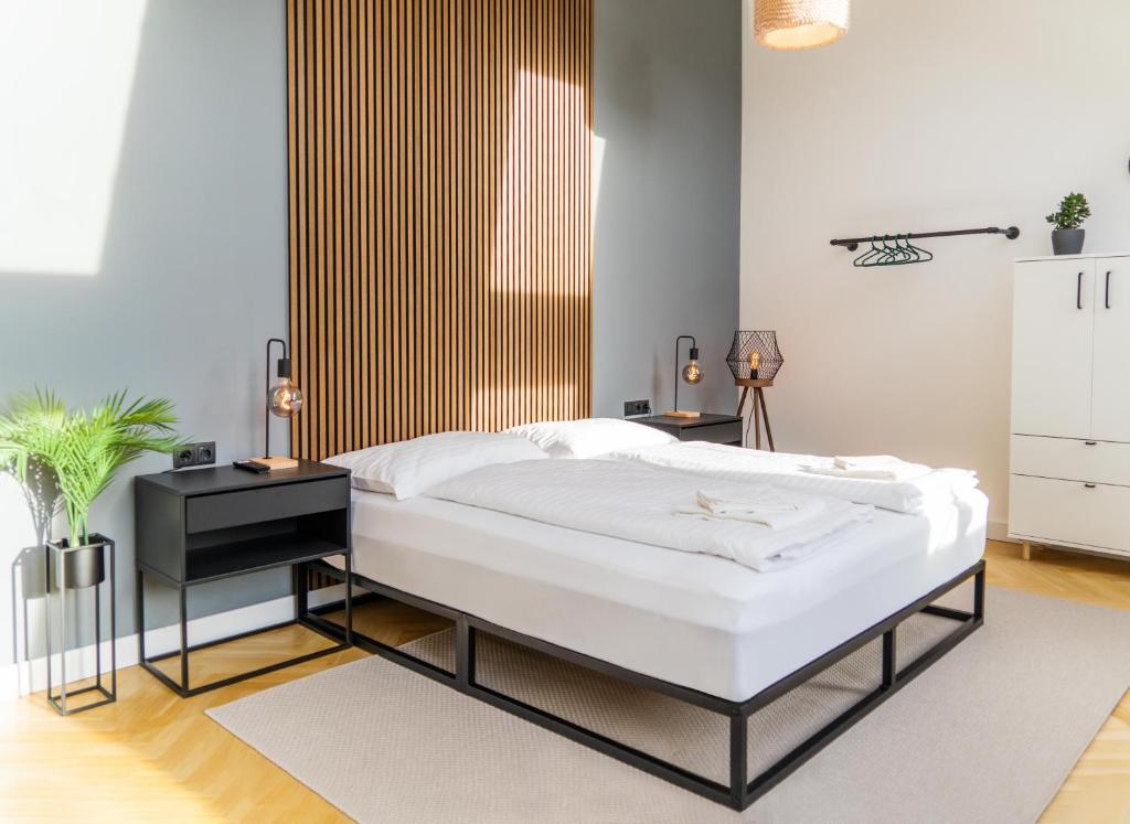 1 dormitorio con 1 cama y 2 mesitas de noche en MyFlat - Bright Apartment near Central Station, en Viena