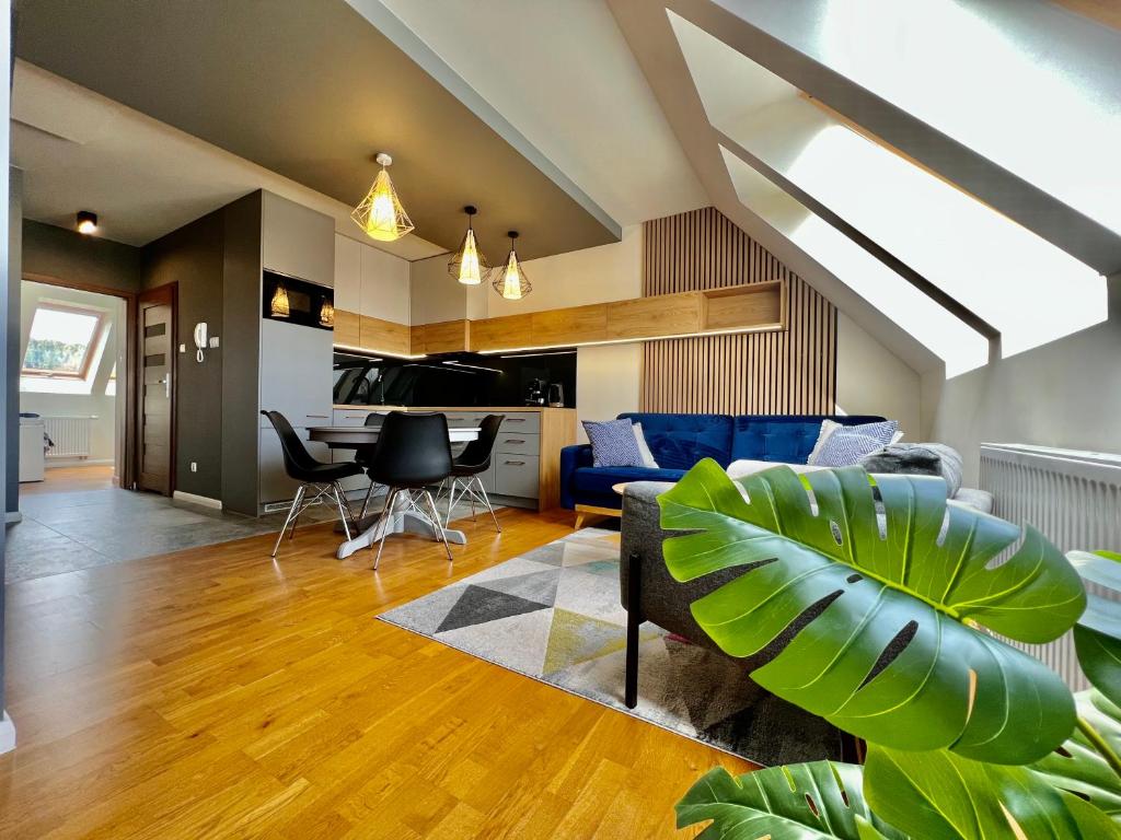 - un salon avec un canapé bleu et des chaises dans l'établissement Apartament 30, à Polanica-Zdrój