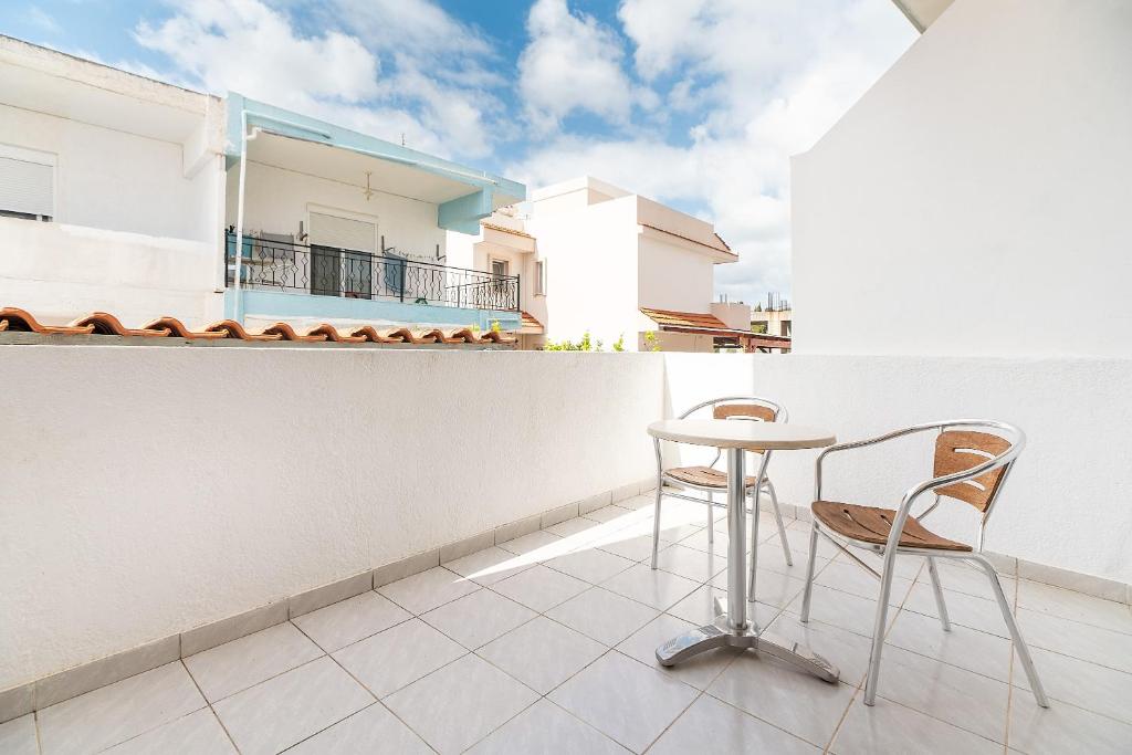 a balcony with a table and chairs on a building at Acapulco 4 in Afantou