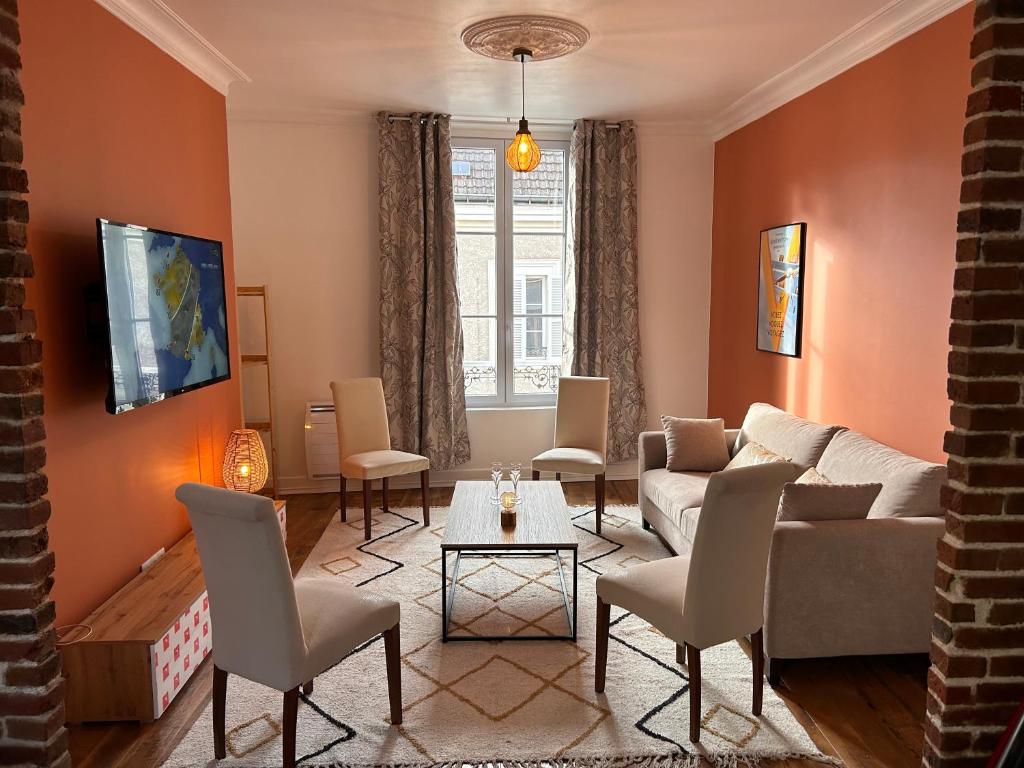 un salon avec un canapé et des chaises dans l'établissement Appartement chic et cosy, à Épernay