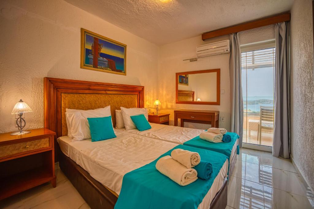 a bedroom with two beds with towels on them at Elounda Residence Resort & Waterpark in Elounda