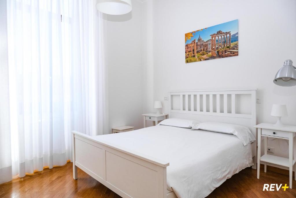 ローマにあるMecenate Apartment Colosseumの白いベッドと白いカーテンが備わる白いベッドルーム1室
