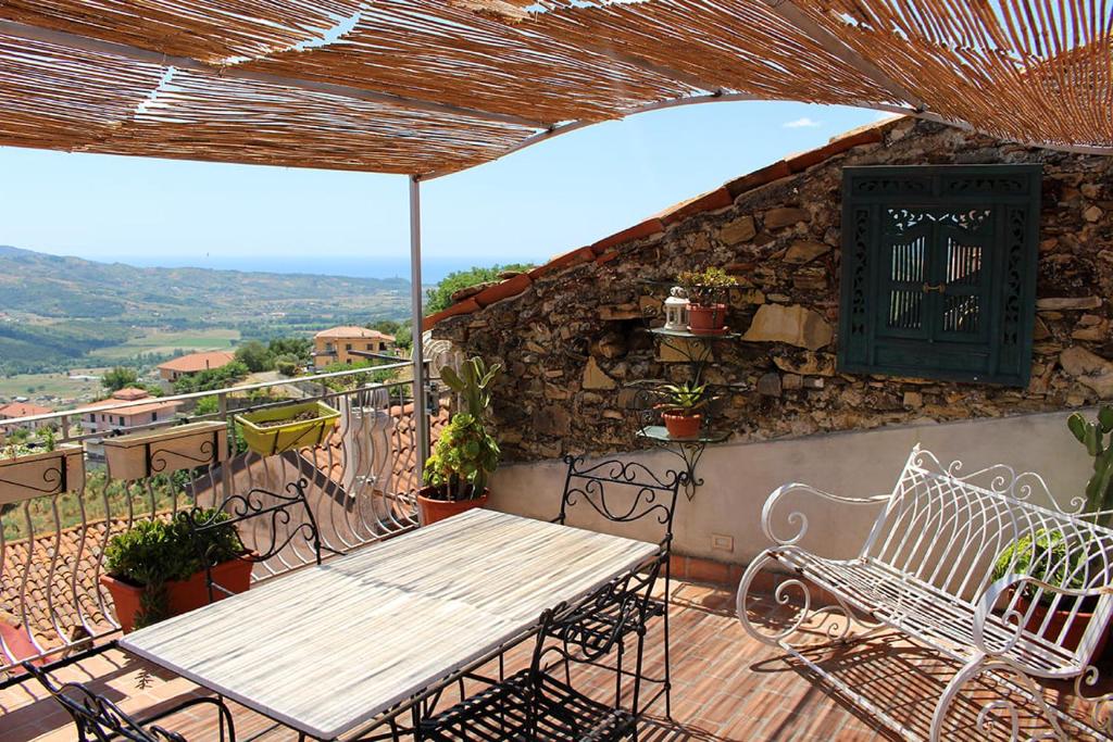 d'une terrasse avec une table et des chaises en bois sur un balcon. dans l'établissement La Casa Dei Ciottoli, à Castelnuovo Cilento