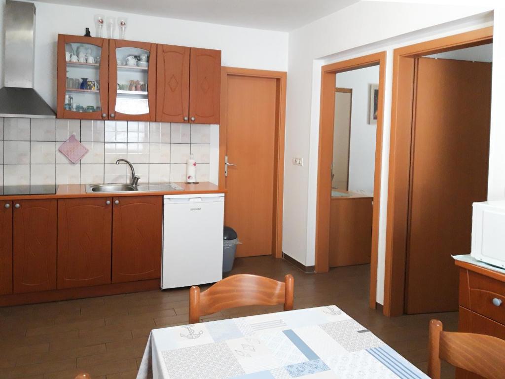 una cucina con armadi in legno e un tavolo con una tovaglia di Apartments Igor a Capodistria