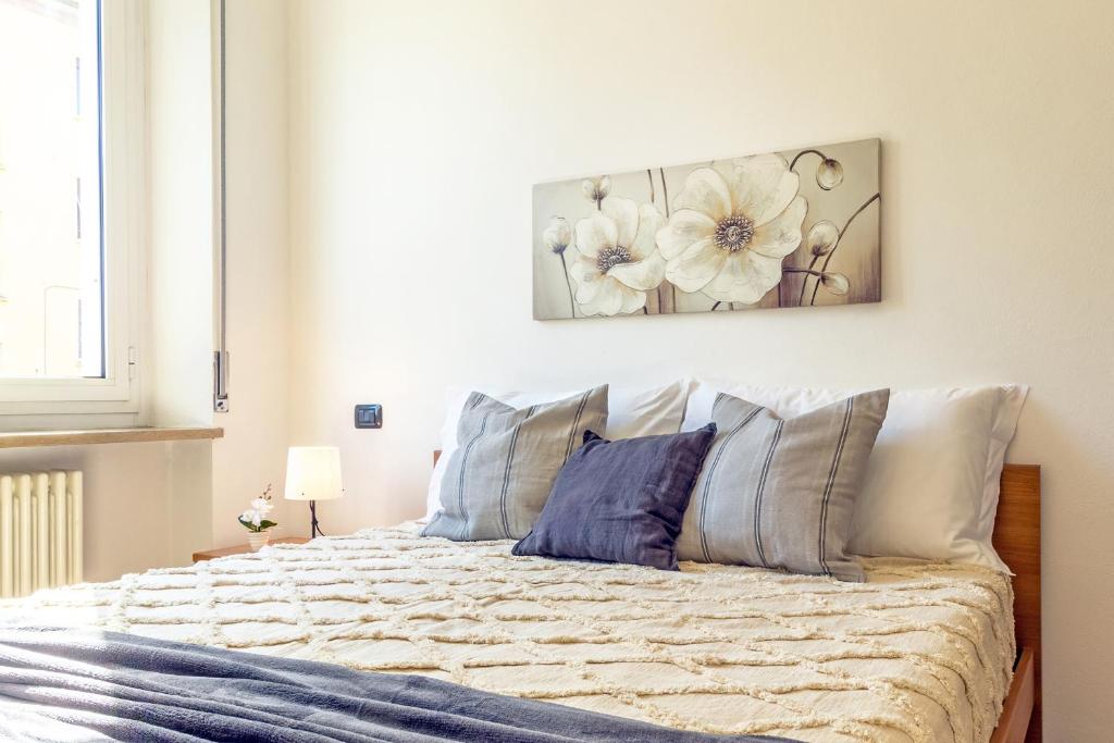 ein Schlafzimmer mit einem Bett mit einem Blumengemälde an der Wand in der Unterkunft Virginia Apartments in Parma