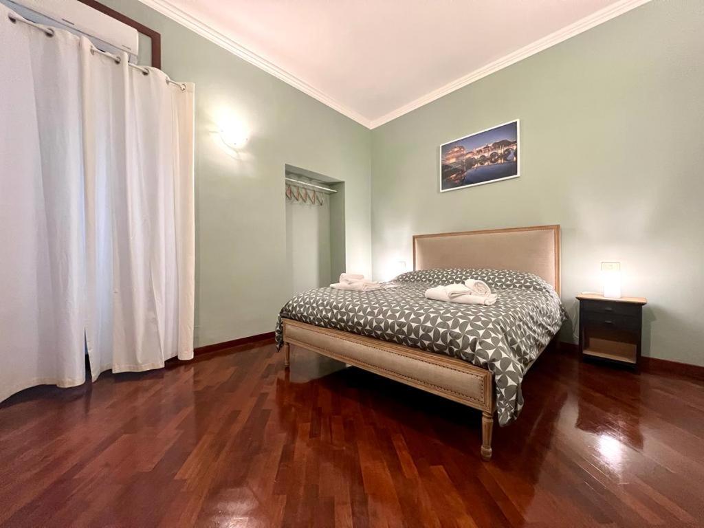 una camera da letto con un letto e un pavimento in legno di Inn Sistina Home a Roma