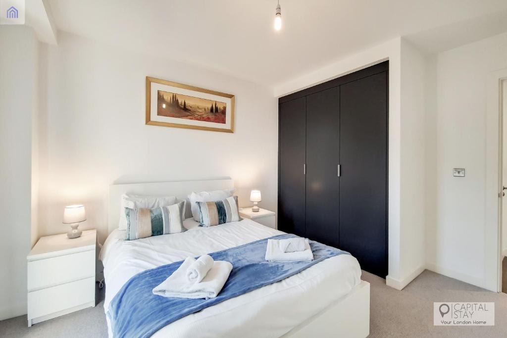 a bedroom with a large bed with two towels on it at Deluxe One Bed Apartment by London ExCeL in London