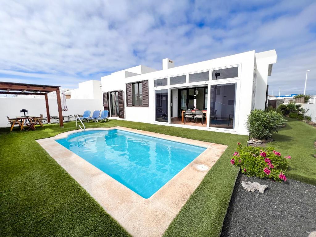 een huis met een zwembad in de tuin bij Casa Sol y Mar Azul un'oasi a due passi dal mare in Playa Blanca