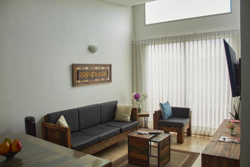 ein Wohnzimmer mit einem Sofa und einem Tisch in der Unterkunft Apartamento completo tipo vintage en villeta in Villeta