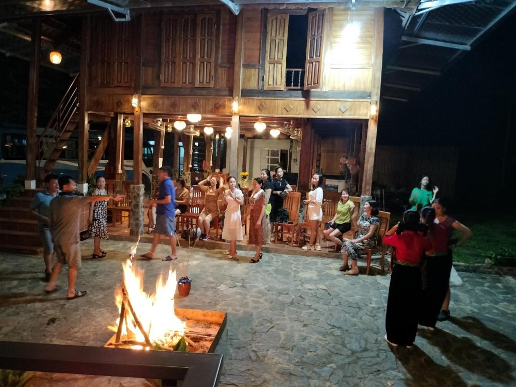 eine Gruppe von Menschen, die um eine Feuerstelle stehen in der Unterkunft Duong Thim Homestay Mai Chau in Mai Châu