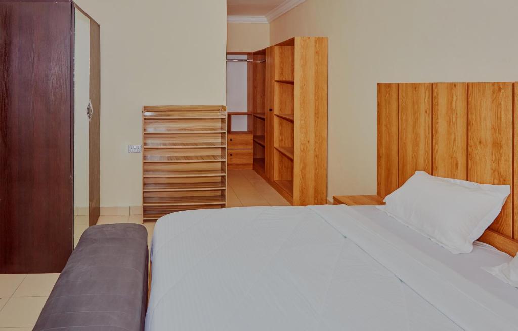 sypialnia z białym łóżkiem i szafą w obiekcie Mainstream Shortlet Apartment Ltd w mieście Gbogije