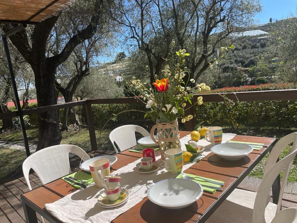 einen Tisch mit Stühlen und eine Vase mit Blumen darauf in der Unterkunft Camper Village in Santo Stefano al Mare