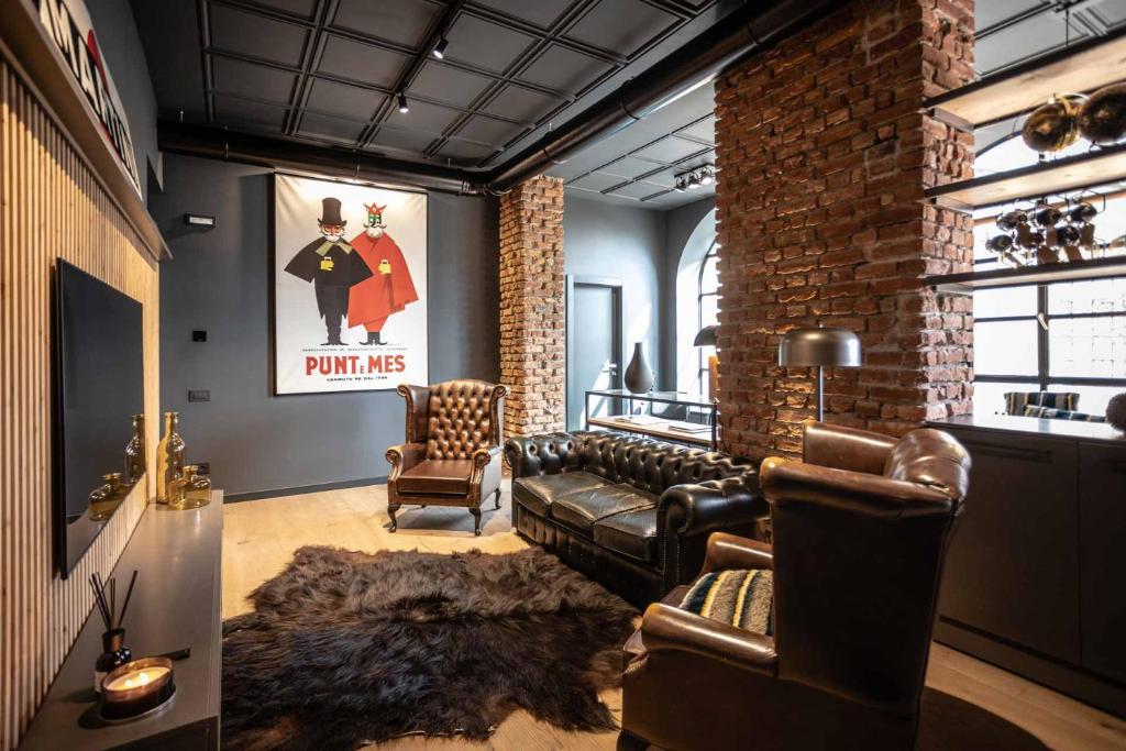 a living room with a couch and a brick wall at AR Prestige Penthouse - TriBeCa Loft in Bergamo