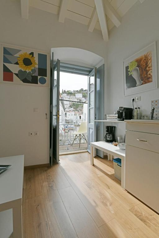 a kitchen with a table and a view of a balcony at Centrál in Hydra