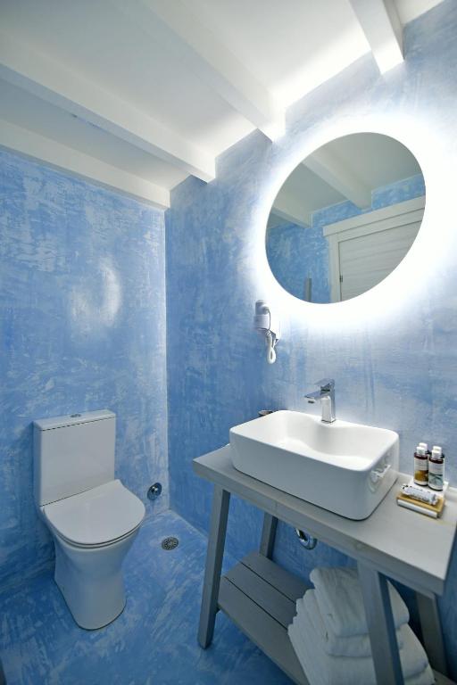a blue bathroom with a sink and a mirror at Centrál in Hydra