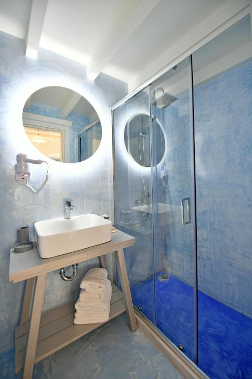 a bathroom with a sink and a shower with a mirror at Centrál in Hydra