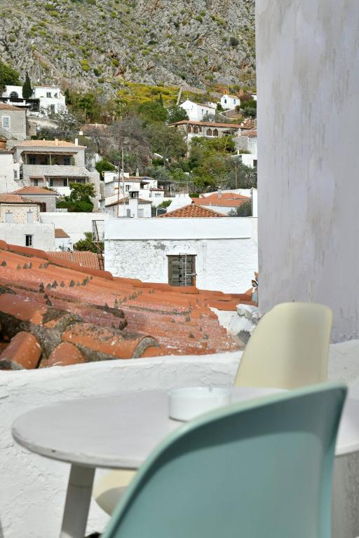 a table and chairs in a room with a view of a city at Centrál in Hydra