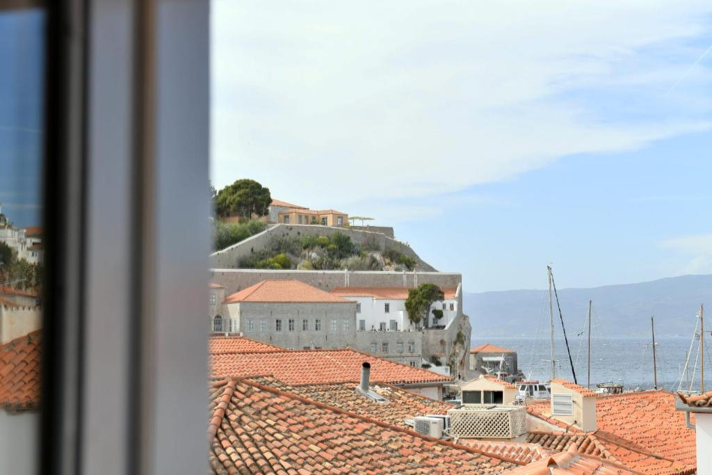 a view of the roofs of a town with a house on a hill at Centrál in Hydra