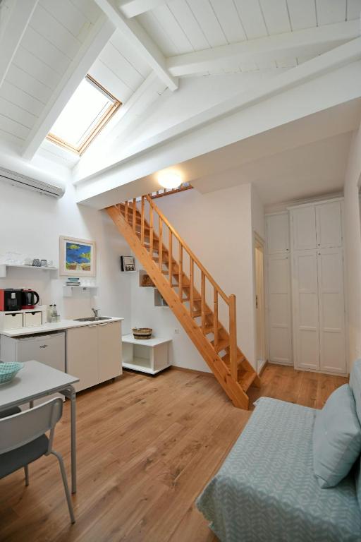a living room with a staircase and a kitchen at Centrál in Hydra