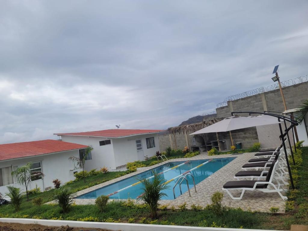 a pool with lounge chairs next to a building at LA POSADA DE NEIZAN in Bocapán