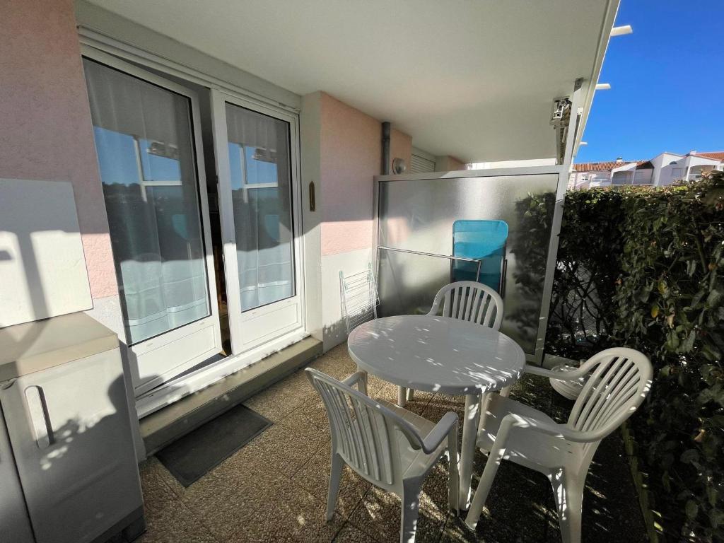 une table et des chaises sur le balcon d'un bâtiment dans l'établissement Studio Centre-St Palais avec Terrasse et Garage, Proche Plages et Attractions - FR-1-550-28, à Saint-Palais-sur-Mer