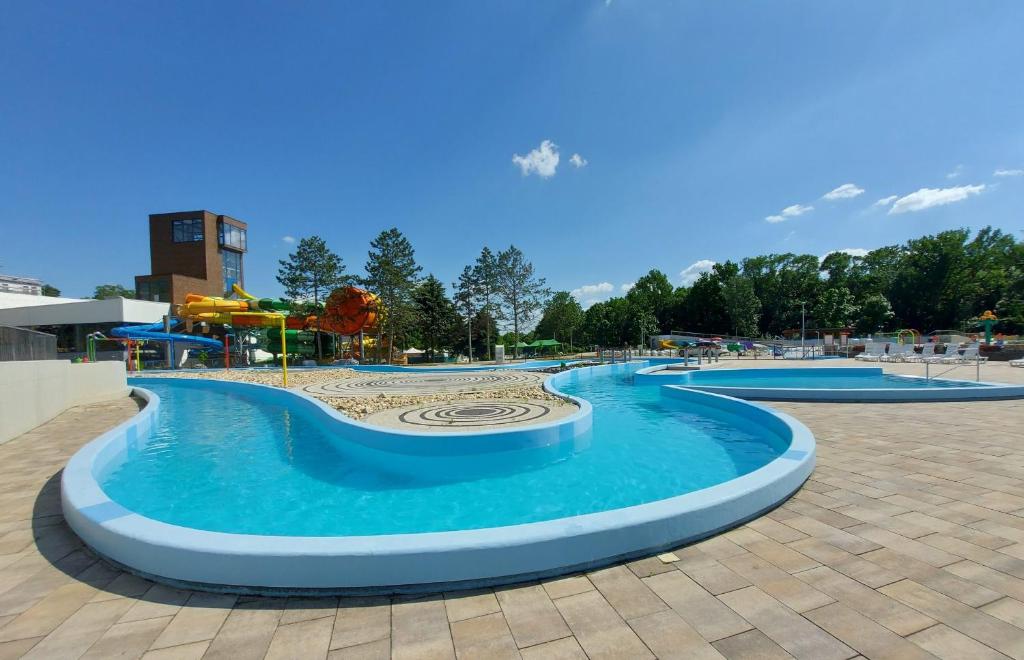a swimming pool in a park with blue water at Ceremoniár in Poľný Kesov