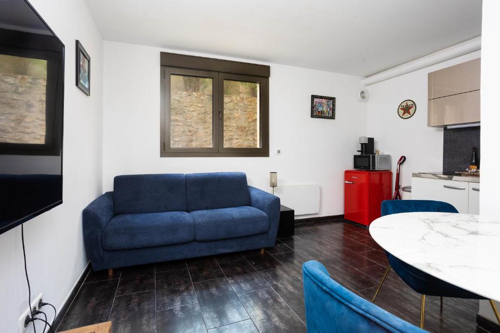 a living room with a blue couch and a table at Charmant Studio à Neuilly-sur-Marne in Neuilly-sur-Marne