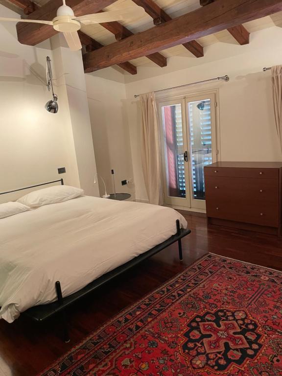 - une chambre avec un grand lit et un tapis rouge dans l'établissement VIA BRASCHI SESSANTASEI, à Cesena
