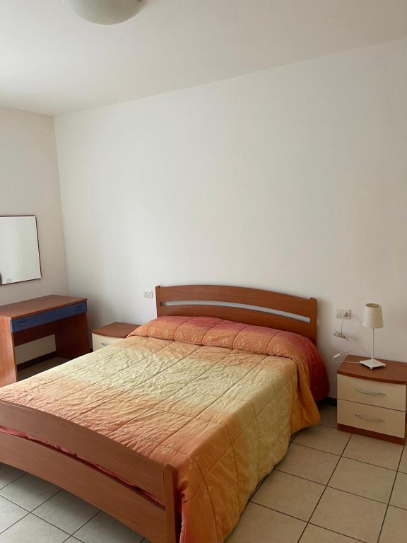 1 dormitorio con 1 cama, 2 mesas y espejo en Residenza il Ciliegio en Buscate