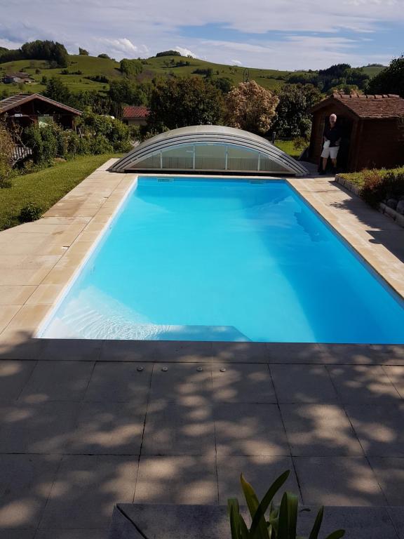 a large blue swimming pool in a yard at Les collines 