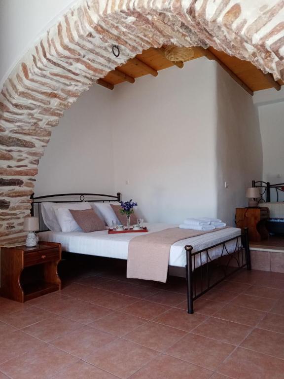 a bedroom with a bed and a stone wall at Monitsia Traditional House in Khalkíon