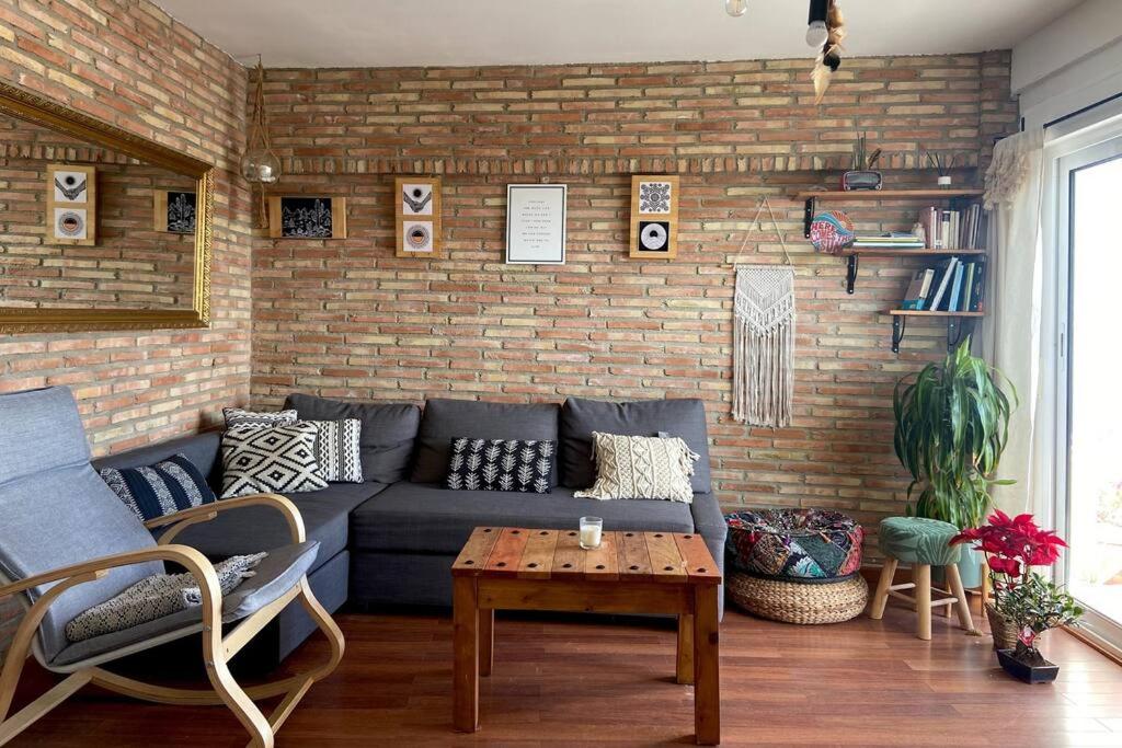 a living room with a couch and a brick wall at Bonito apartamento con vistas al mar in Las Negras