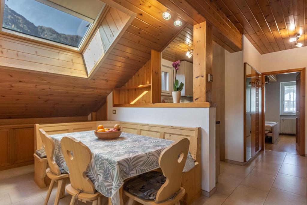 普雷達佐的住宿－DolomiApartments - Casa Lagorai，一间带桌椅和天窗的用餐室