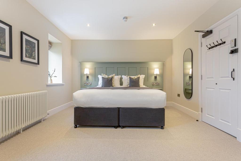 a large bedroom with a large bed with white sheets at The Old Mill Inn in Dearham