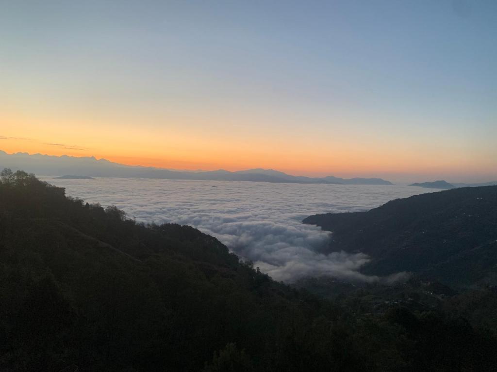 a view of a valley of clouds at sunset at Mountain Resort in Nagarkot