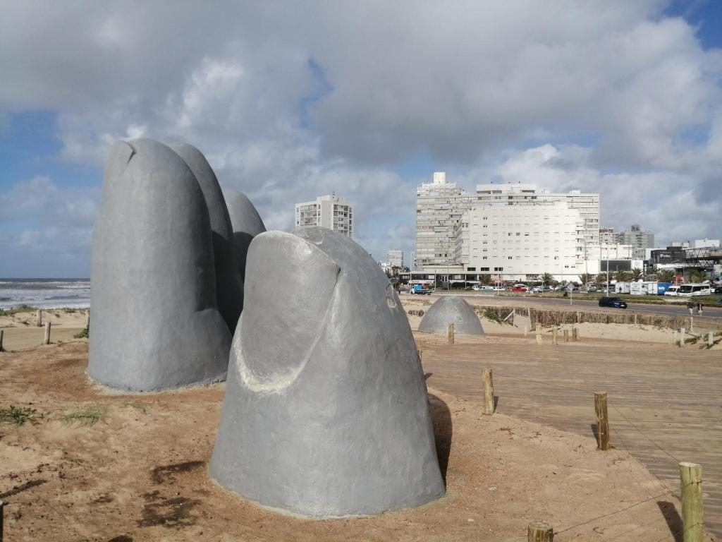 a sculpture of a hand on the beach at ESCAPADA a PdE !! in Punta del Este