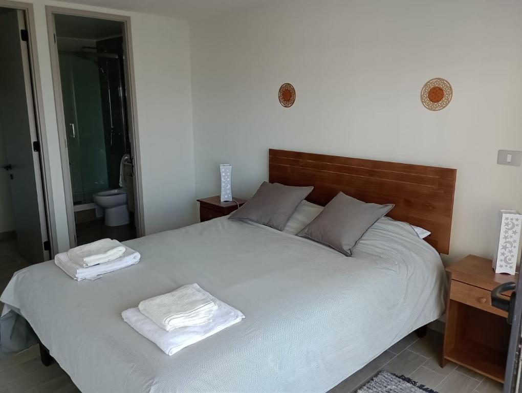a bedroom with a large bed with two towels on it at Apartamento cómodo y espectacular en Concón !! in Concón