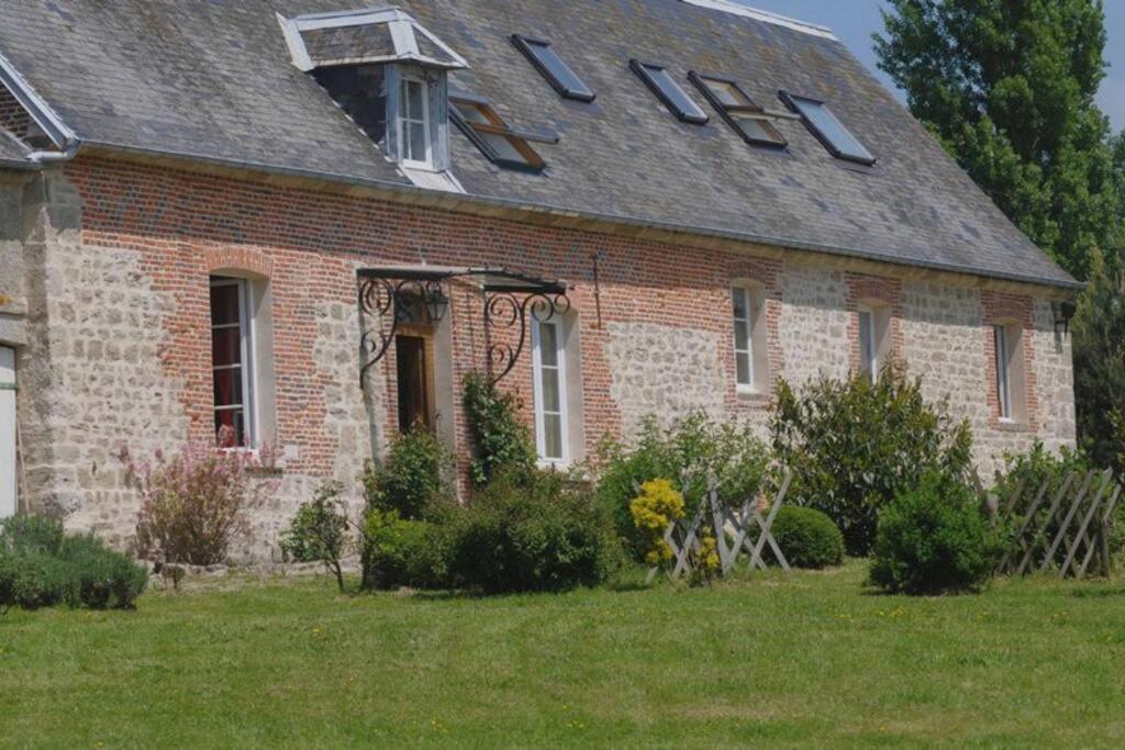 ein altes Backsteinhaus mit einem Gameradach in der Unterkunft L'Etoile de Forges in Longmesnil