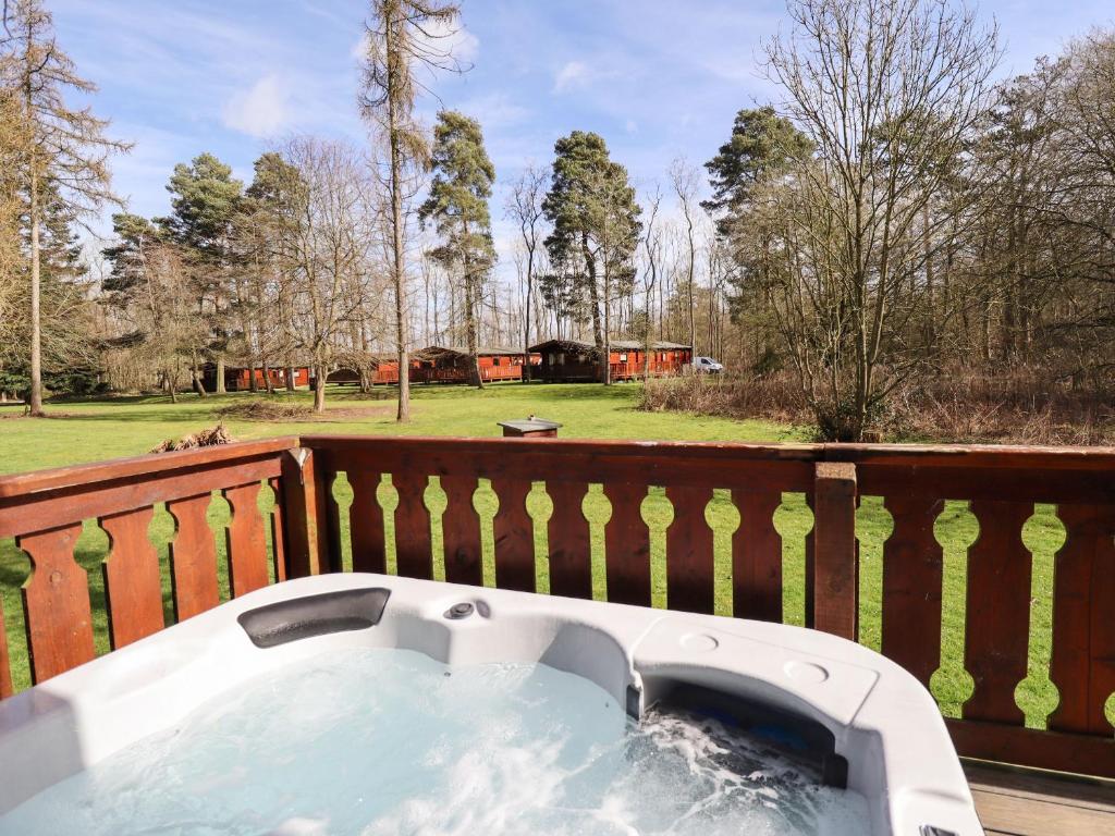 a hot tub on a deck with a fence at iLodge 73 in Louth