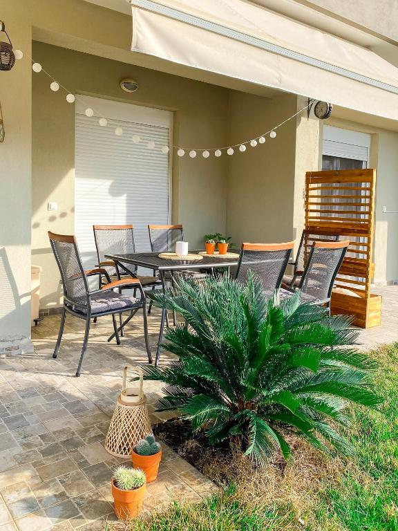 a patio with a table and chairs on a patio at Neroli Apartments in Nikiti