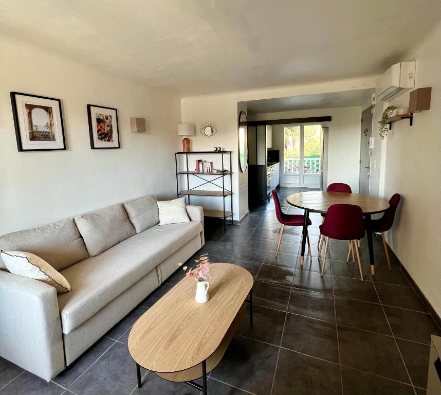 un salon avec un canapé et une table dans l'établissement Joli T2 proche plage et parking privé, à Bandol