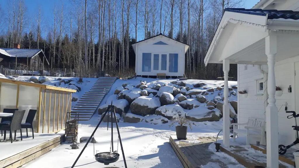 Finnerödja的住宿－Nieuw Tiny House met uitzicht op het Skagern meer，一座被雪覆盖的院子,房子和建筑物