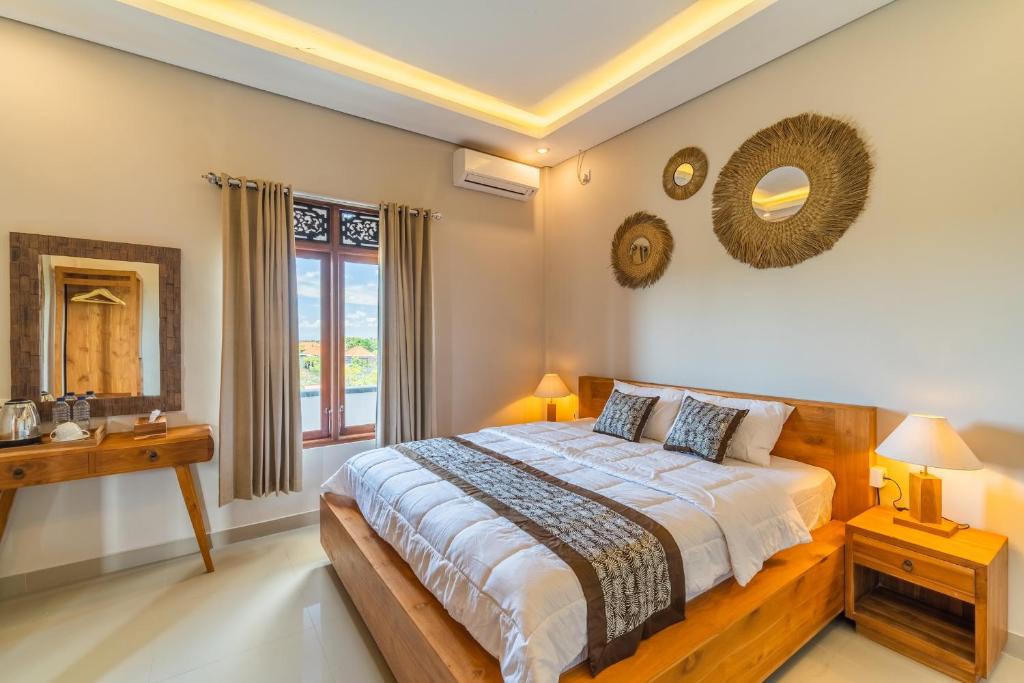 a bedroom with a large bed and a window at The Oni Bisma in Ubud