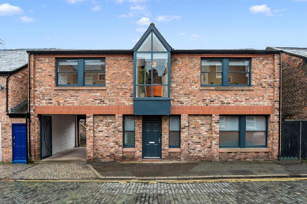 an old brick house with a large window at Host & Stay - The Coachouse at Pilgrim St in Liverpool