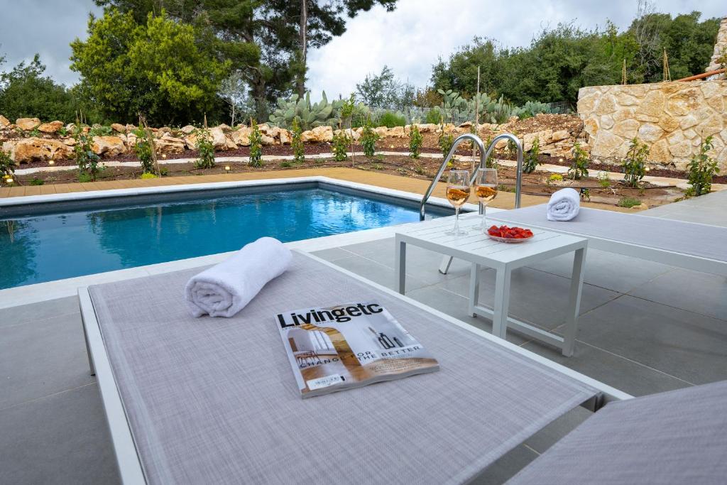 a table with a magazine on it next to a pool at סוויטות לזוגות בכפר ורדים in Kefar Weradim