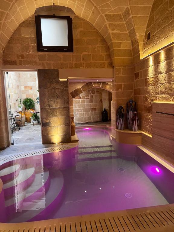 une piscine intérieure avec des lumières violettes dans un bâtiment dans l'établissement B&B Corte Dei Figuli, à San Pietro in Lama