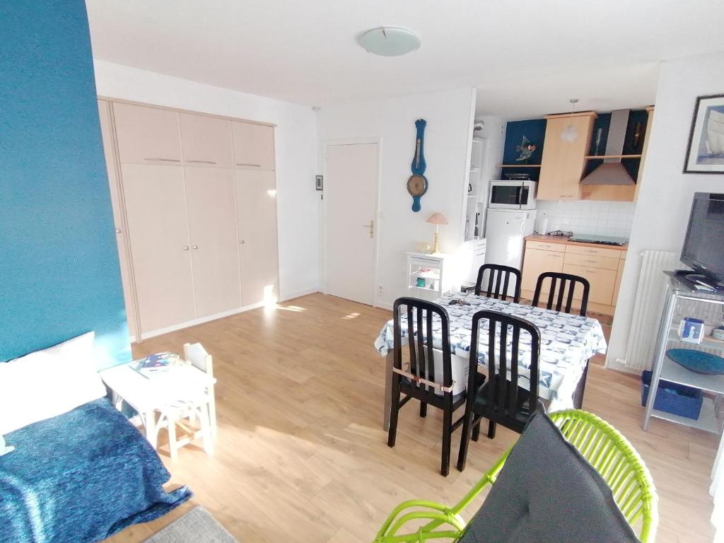 een woonkamer met een tafel en stoelen en een keuken bij Studio proche mer in Dinard