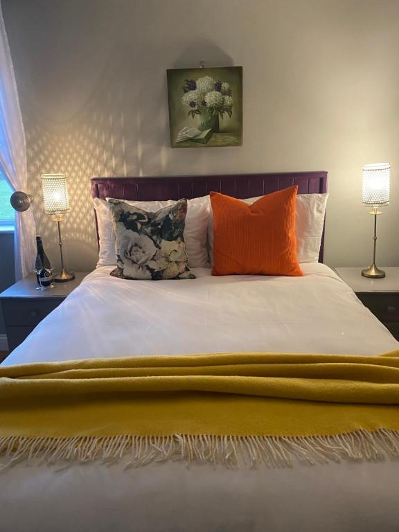 a bedroom with a large bed with orange pillows at An Riasc B&B in Ballydavid